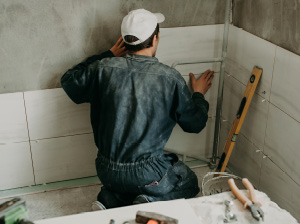 Man tiling a bathroom wall