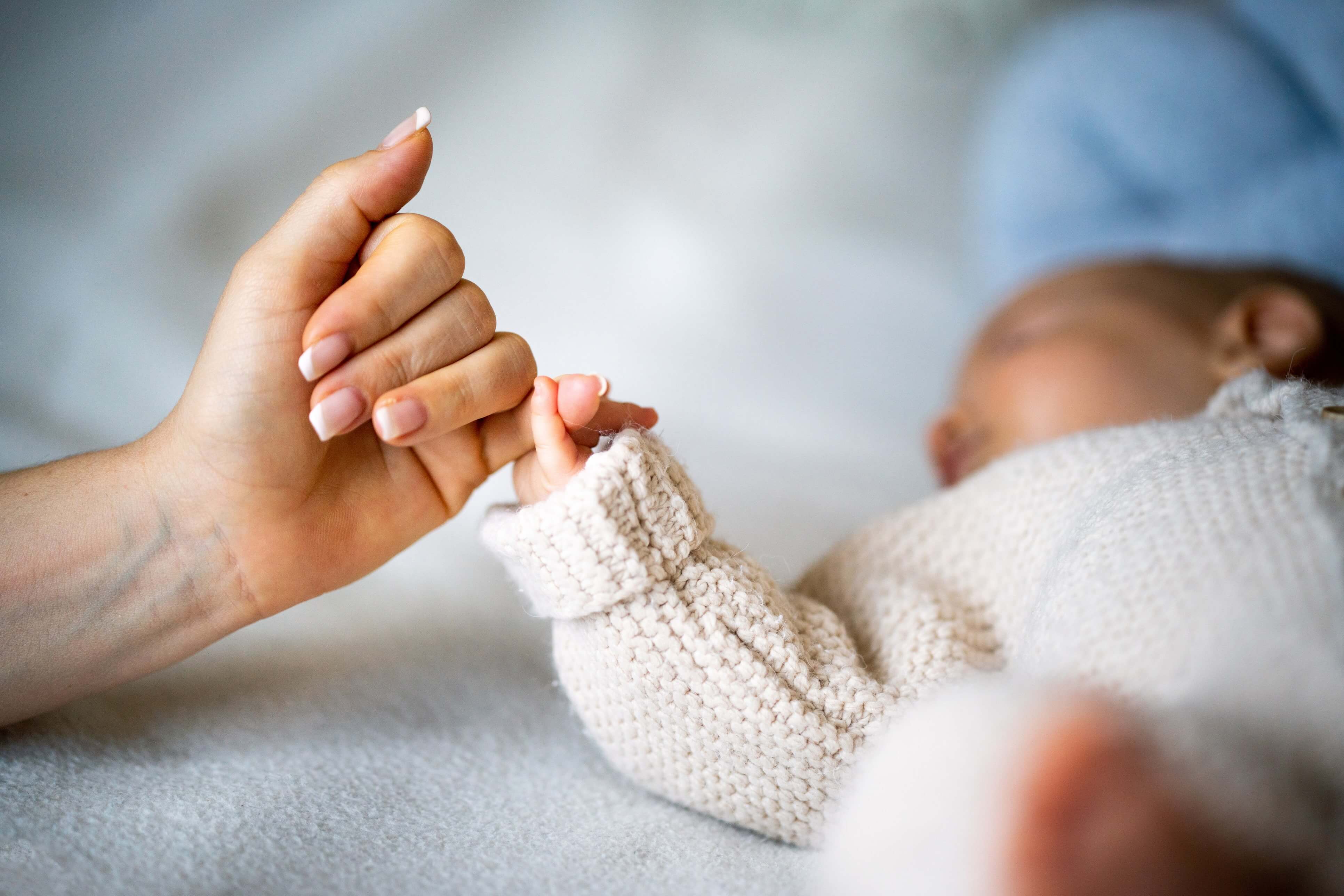 Woman and baby holding hands